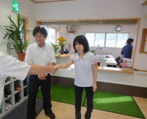 くまさんと固い握手を交わす梶川さん(右)と福永施設長