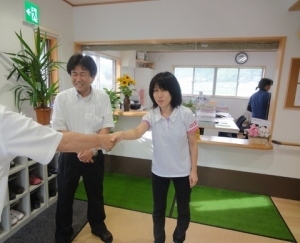 くまさんと固い握手を交わす梶川さん（右）と福永施設長