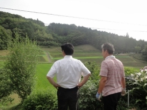 草刈りの仕上がりを見る清田芳朗さんとくまさん
