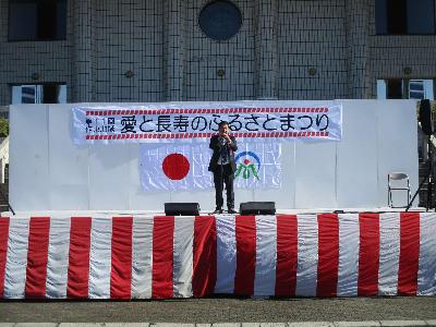 愛と長寿のふるさとまつりのステージで挨拶をする萩原市長