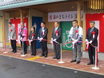 湯のまちトイレ落成式でテープカットをする萩原市長